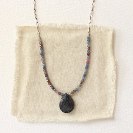 The cleo sapphire necklace styled on tan linen