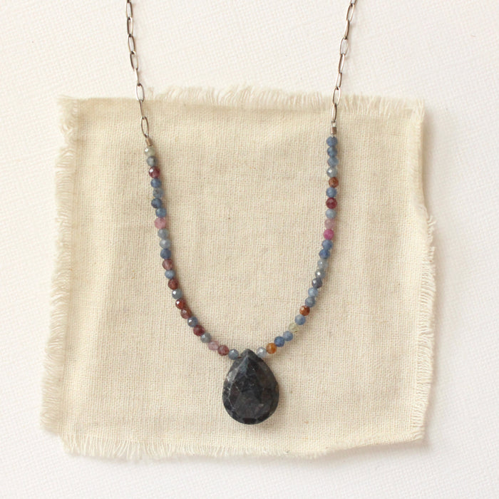 The cleo sapphire necklace styled on tan linen