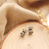The columbine burst post earrings styled on wood to show the butterfly earbacks