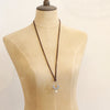 A mannequin wearing the columbine hoop pearl adjustable leather necklace in the long style