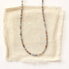 The dainty sapphire necklace styled on tan linen