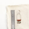 A moab arch earring next to a ruler for size reference