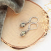The perfect wrap dalmatian jasper earrings styled on wood with gray velvet and dried grass