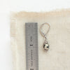 A dalmtian jasper earring next to a ruler for size reference