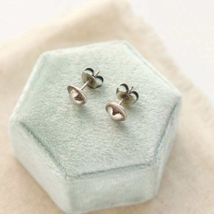 The silver heart earrings styled to show the butterfly ear backs