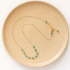 The emerald collar necklace styled on a tan plate to show the adjustable lobster clasp closure