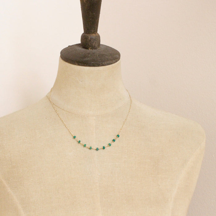 A mannequin wearing the emerald collar necklace
