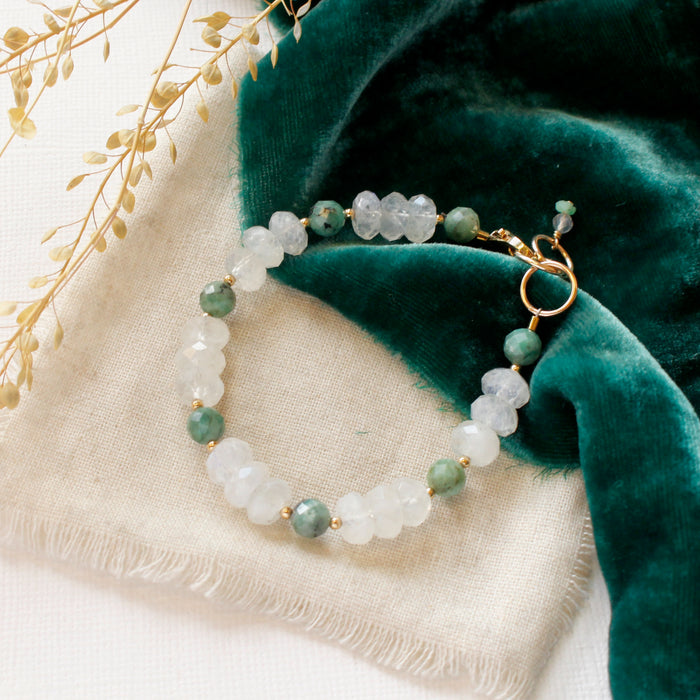 The emerald and moonstone bracelet styled on tan linen with green velvet and dried grass