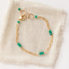 The emerald paperclip bracelet styled on tan linen
