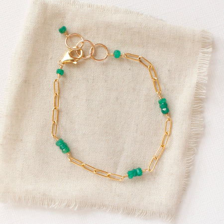 The emerald paperclip bracelet styled on tan linen