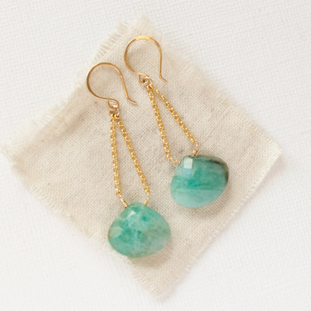 The emerald swing earrings styled on tan linen