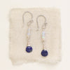 The opal and lapis drop earrings styled on tan linen