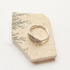The feather embrace ring styled on a tan stone to show the thin band