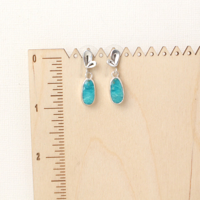The feminine turquoise petal post earrings on a wooden ruler for size reference