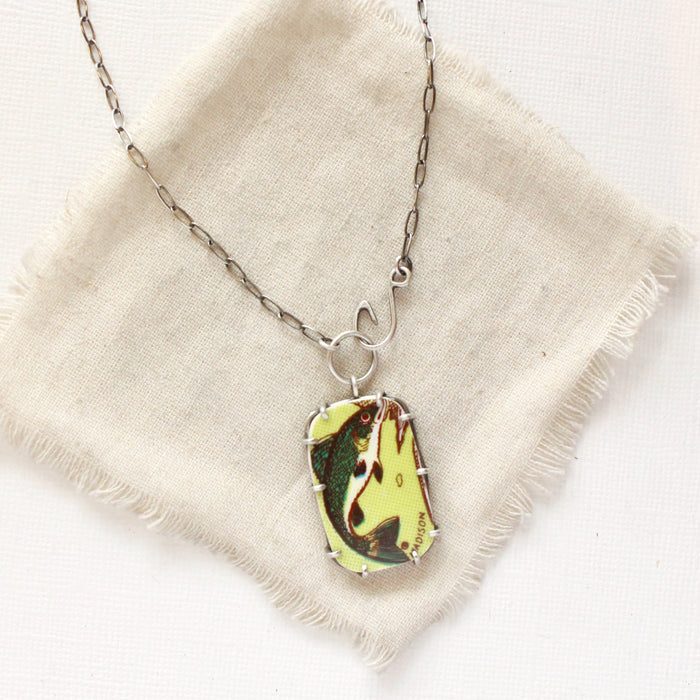 The fish tales vintage plate necklace styled on tan linen