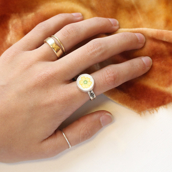 The flower vintage plate ring being worn on a hand