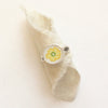 The flower vintage plate ring styled on rolled tan linen