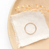 The hammered gold fill stacked ring styled on a tan plate with linen and dried grass