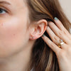 The gold nugget posts being worn in an ear