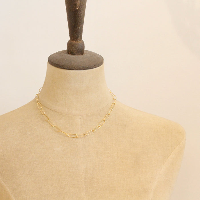 A mannequin wearing the gold paperclip necklace