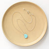 The golden hills turquoise necklace styled on a tan plate to show the adjustable lobster clasp closure
