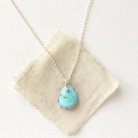 The golden hills turquoise necklace styled on tan linen