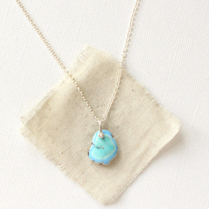 The golden hills turquoise necklace styled on tan linen