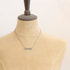 A mannequin wearing the green apatite bronze bar necklace