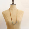 A mannequin wearing the long style of the apatite adjustable leather necklace