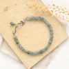 The green apatite cube bracelet styled on a tan rock with linen and dried grass