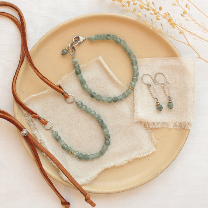 The apatite cube bracelet styled on a tan plate with the matching necklace and earrings