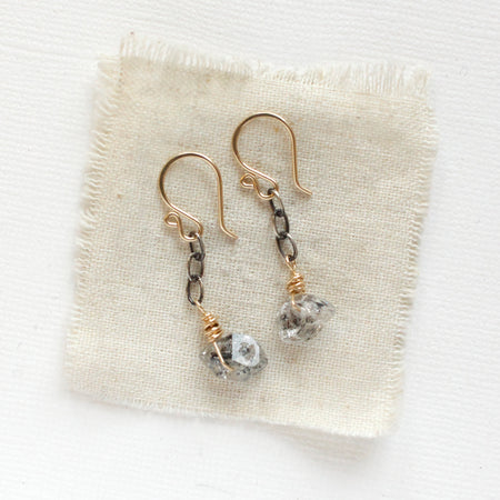 The herkimer diamond mixed metal earrings styled on tan linen