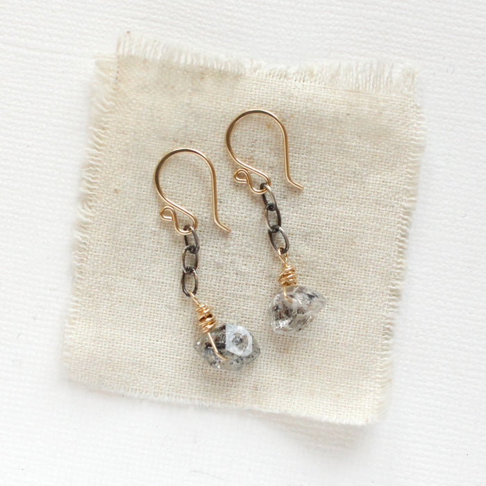 The herkimer diamond mixed metal earrings styled on tan linen