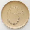 The herkimer diamond collar necklace styled on a tan plate to show the adjustable lobster clasp closure