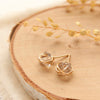 The gold wrapped herkimer diamond post earrings styled on wood with linen and dried grass