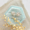 The silver wrapped herkimer diamond post earrings styled on a velvet box with linen and dried grass