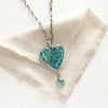 The hubei turquoise heart and grandidierite necklace styled on tan linen