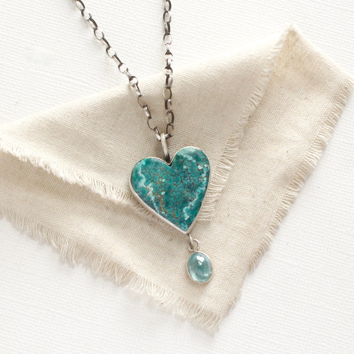 The hubei turquoise heart and grandidierite necklace styled on tan linen