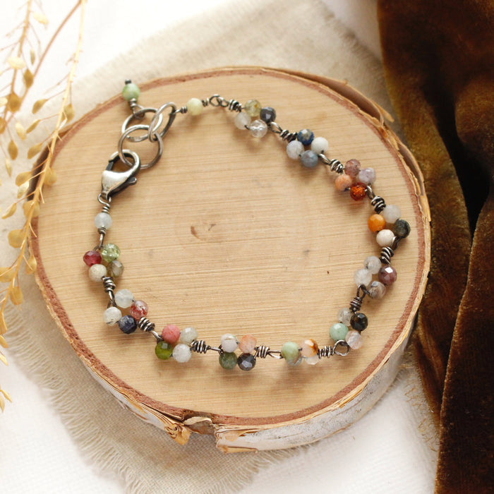 The kaleidoscope bracelet styled on wood with brown velvet and dried grass