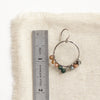 A kaleidoscope hoop earring next to a ruler for size reference
