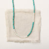 The beaded kingman turquoise and opal necklace styled on tan linen