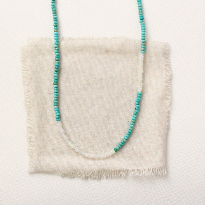 The beaded kingman turquoise and opal necklace styled on tan linen