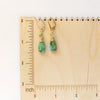 The kingman turquoise and peridot earrings on a wooden ruler for size reference