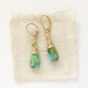 The kingman turquoise & peridot earrings styled on tan linen