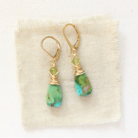 The kingman turquoise & peridot earrings styled on tan linen