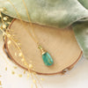 The kingman turquoise and peridot necklace styled on wood with green velvet and dried grass