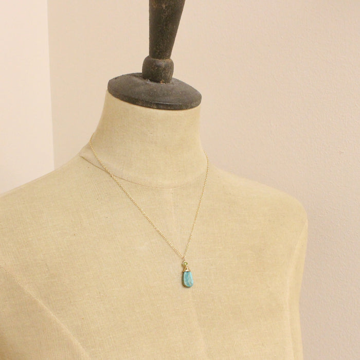 A mannequin wearing the kingman turquoise and peridot necklace 