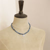 A mannequin wearing the knotted aquamarine rose necklace