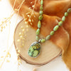 The knotted elisa turquoise and hubei turquoise necklace styled on wood with orange velvet and dried grass