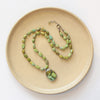 The knotted elisa and hubei turquoise necklace styled on a tan plate to show the adjustable lobster clasp closure